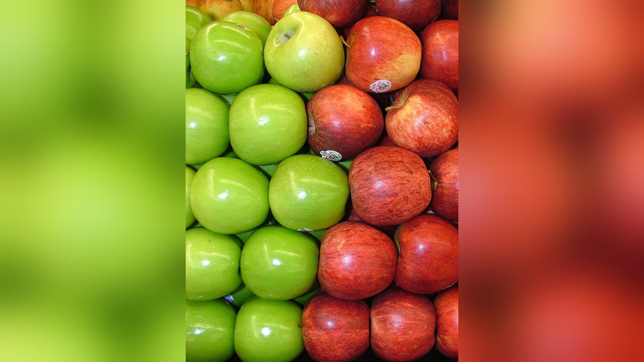 Green and red apples packed together in rows