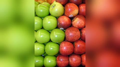 Green and red apples packed together in rows
