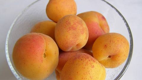 Ripe apricots in a clear glass bowl