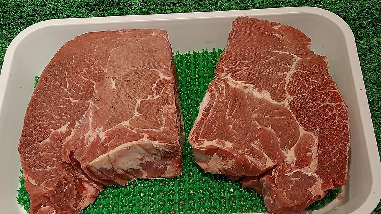 Two raw beef steaks in a tray
