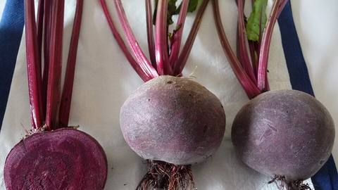 Whole and halved beetroots with their stems