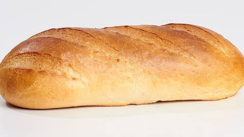 A single golden bread roll on a white background