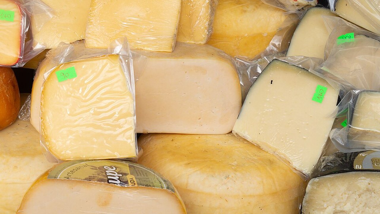 Un trozo de queso cheddar con pequeños cubos