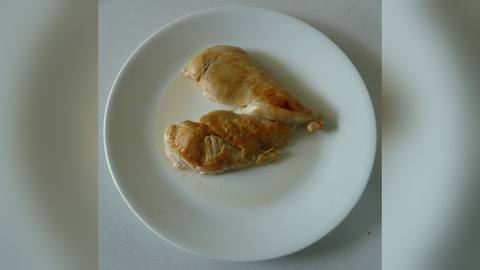 Plain cooked chicken breast pieces on a white plate