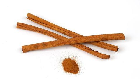 Cinnamon sticks and a small pile of ground cinnamon