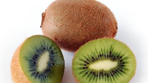 Whole and halved kiwi fruit showing the green flesh