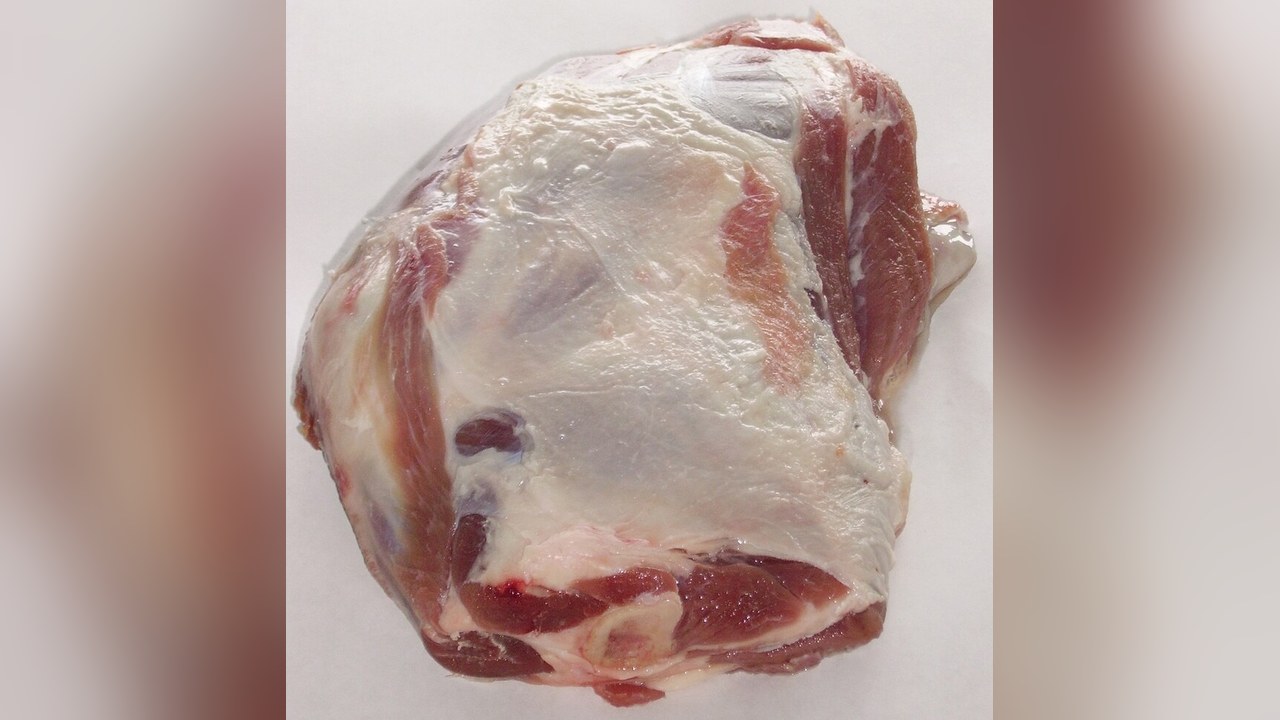 A raw joint of lamb with white fat