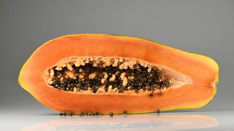 A halved papaya showing the black seeds