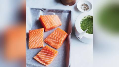 A raw salmon fillet on a board