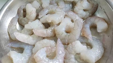 Peeled raw shrimp in a metal bowl